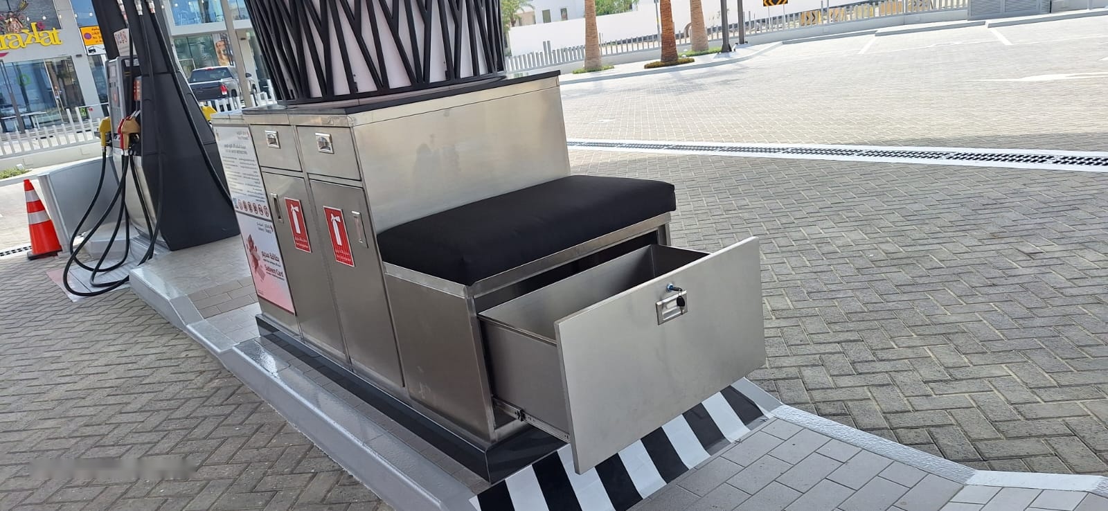 Stainless steel fuelling-island unit with open storage drawer and cushioned seat