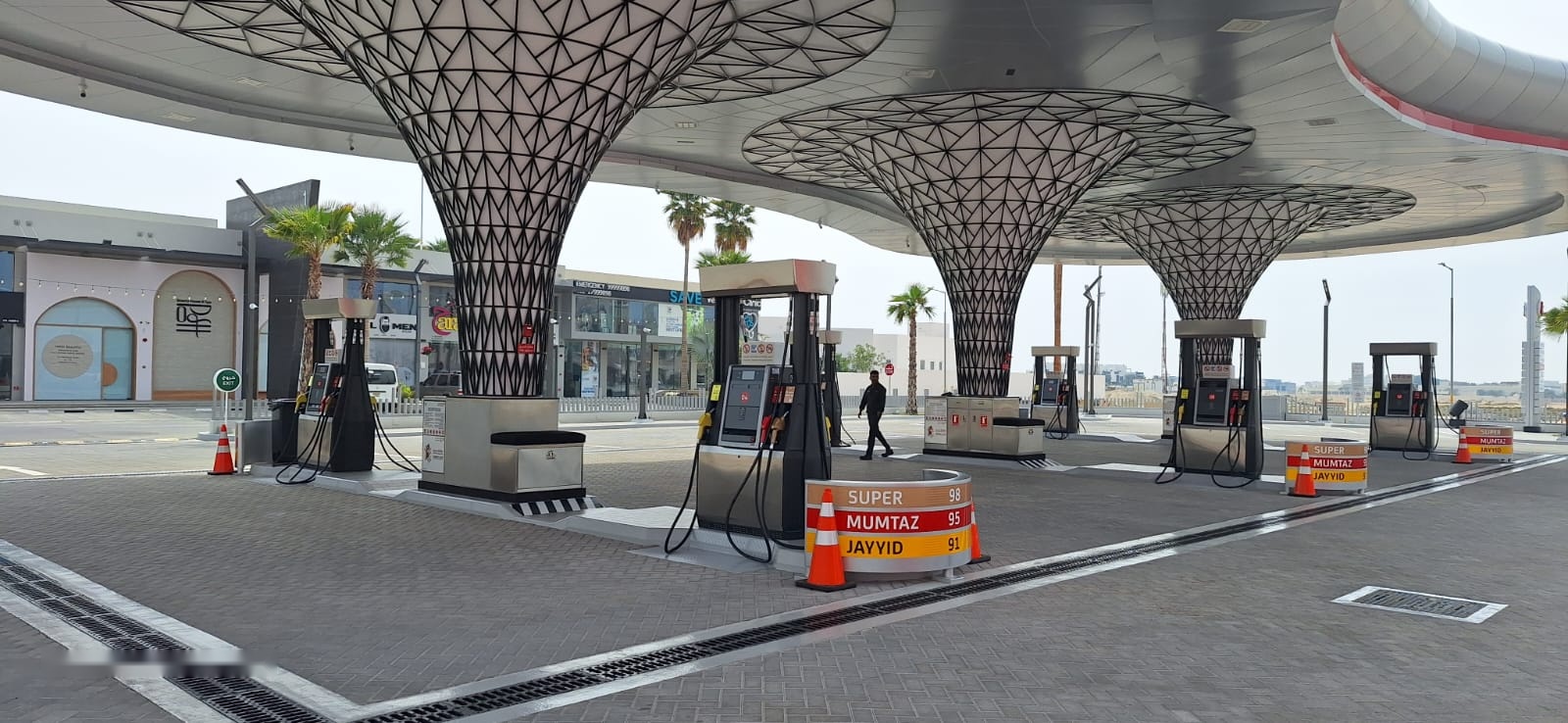 Petrol station forecourt in Bahrain with fuel dispensers under a lattice-column canopy