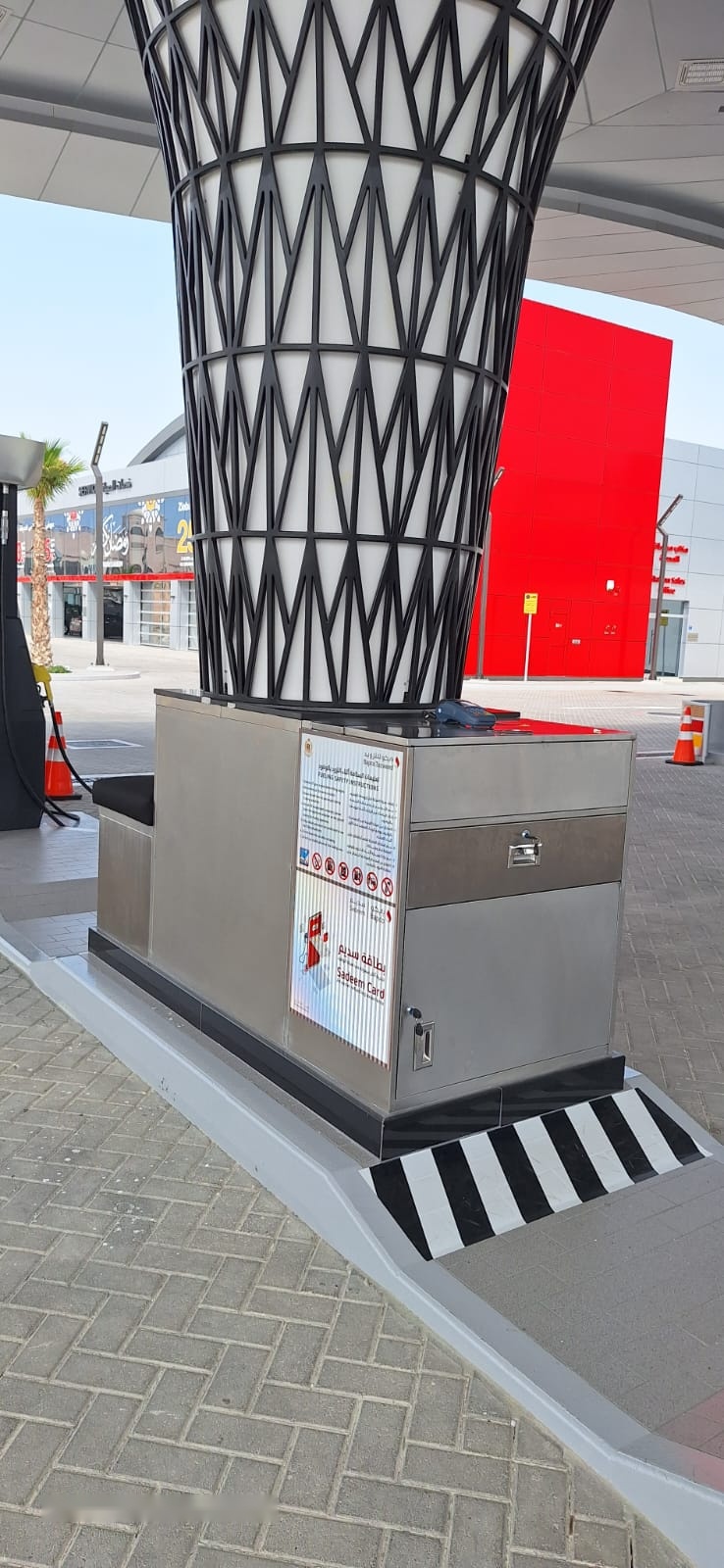 Stainless steel unit built around a lattice canopy column on a petrol station forecourt